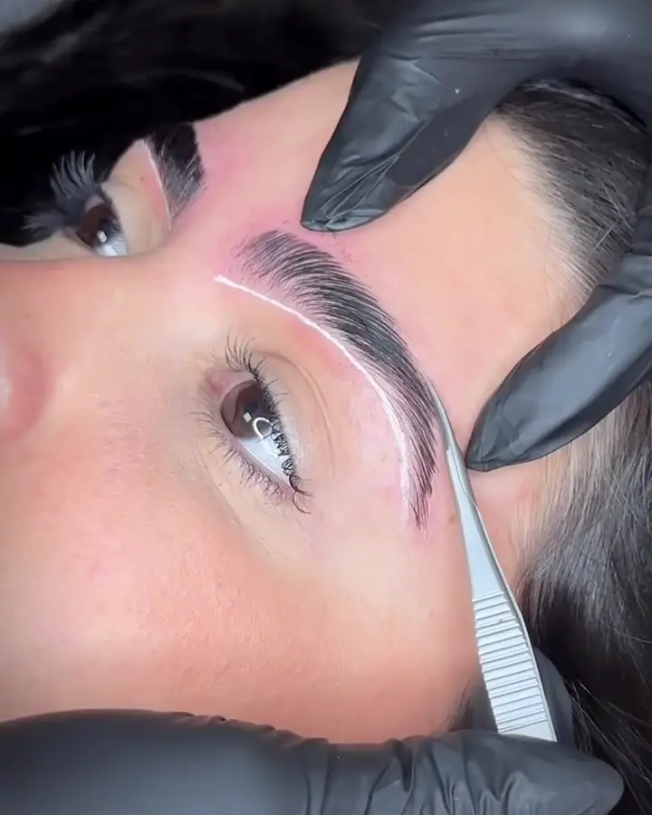 Jéssica mapping a client's brow shape before the procedure